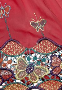 Tela roja con intrincadas mariposas bordadas en dorado, azul y púrpura, que cuentan con un patrón de encaje decorativo y detalles texturizados.