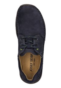 Ciemnoniebieskie zamszowe buty z okrągłym noskiem, kontrastującymi zielonymi przeszyciami i sznurowanym zapięciem. Posiadają brązową podeszwę i beżowe wnętrze.