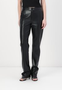 Black leather trousers with a high waist, featuring a front zipper, straight leg design, and smooth texture. Styled with open-toe heels.