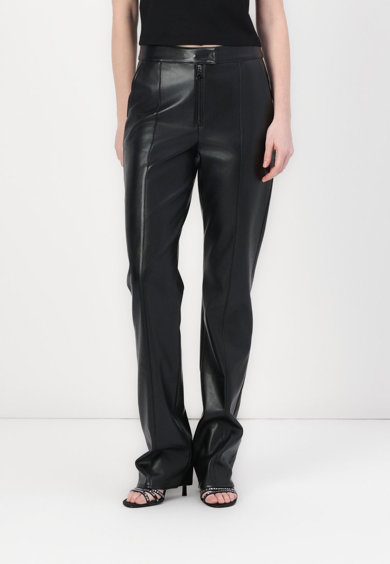 Black leather trousers with a high waist, featuring a front zipper, straight leg design, and smooth texture. Styled with open-toe heels.
