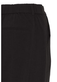 Pantalon noir avec une ceinture élastique et une poche passepoilée unique à l'arrière côté droit.