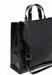 Zwarte leren draagtas met een gladde textuur, rechthoekige vorm, dubbele bovenhandvatten en een afneembare schouderriem. Heeft een minimalistisch ontwerp.