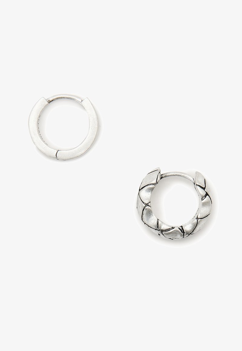 Silver hoop earrings, one smooth and round, the other with textured, layered design, showcasing a polished finish and metallic luster.