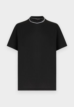 Svart t-skjorte med korte ermer og rund hals, med hvit kant og teksten "Michael Kors" på kragen, vist på hvit bakgrunn.