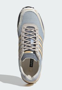 Ανοιχτό μπλε και μπεζ αθλητικό παπούτσι Adidas Adizero για τρέξιμο με επάνω μέρος από δίχτυ, μπεζ κορδόνια και τρεις χρυσές ρίγες στο πλάι, σε άποψη από πάνω.