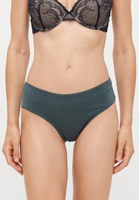 Donkerblauwe katoenen slip met een gladde textuur, met een hoge taille en minimale stiksels langs de randen.