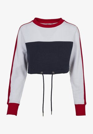 Lühendatud kapuutsiga särk, millel on punane ümar kaelus ja pikad varrukad. Omab sinise ja valge värvibloki ning nööri alumises servas.