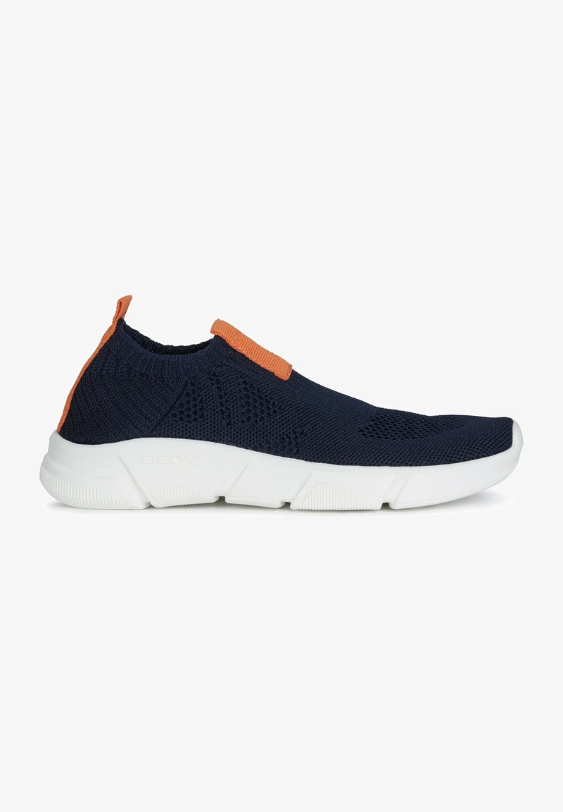 Zapatillas de punto en color navy con suela de goma blanca y parte superior texturizada. Cuenta con un acento naranja en el talón y la lengua para facilitar su uso.