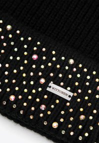 Cappello nero lavorato a maglia con trama a costine, decorato con rhinestones multicolori e un'etichetta argentata con la scritta "WITTCHEN".