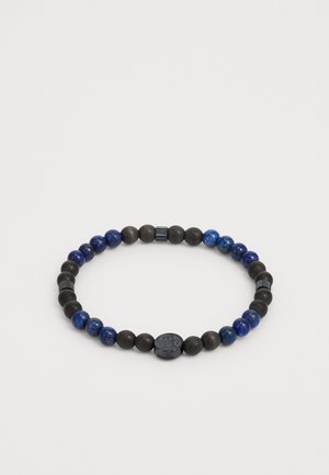 Perlenarmband mit matten und polierten schwarzen Perlen, unterbrochen von blauen Lapislazuli-Perlen, kreisförmiger schwarzer Akzent mit Logo.