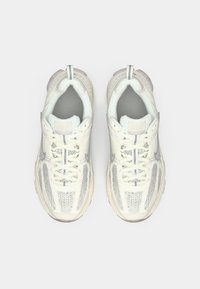 Ténis leves com parte superior em malha e sintético em off-white com detalhes cinza, ponta arredondada e sola acolchoada.