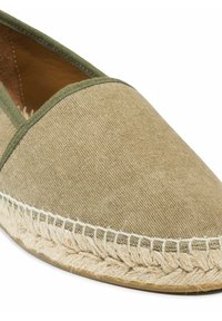 Beige canvas espadrille met groene rand en gevlochten jute zool, ontworpen voor casual gebruik.
