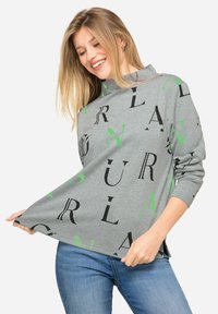 Szara bluza z długim rękawem o luźnym kroju, z mieszanymi typografiami w kolorze czarnym i intensywnej zieleni, wykonana z miękkiego materiału.