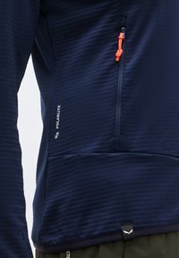 Πολάρλιτ μπουφάν σε ναυτικό μπλε χρώμα με τσεπάκι στο στήθος με φερμουάρ και πορτοκαλί λαβή, υφασμένο ύφασμα.