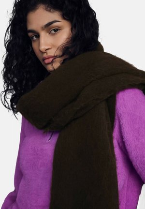 Sciarpa di lana marrone drappeggiata su una maglia in pile viola. La sciarpa ha un aspetto morbido e texturizzato, mentre il pile è soffice e vivace.