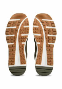 Zapatillas deportivas con suelas de goma, con una textura marrón en el dibujo, media suela blanca y parte superior de color verde oscuro. Diseñadas para ofrecer tracción y comodidad.