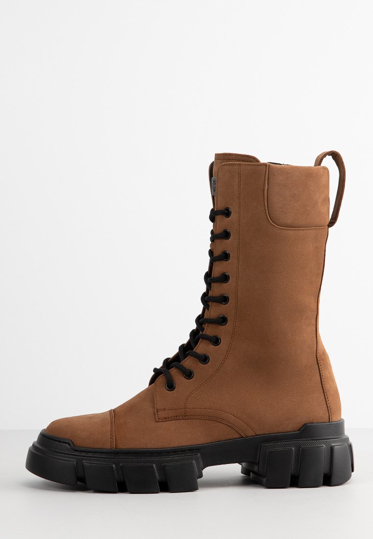 Braune Wildleder-Schnürstiefel mit einer robusten schwarzen Gummisohle, haben einen hohen Schaft und eine Zuglasche auf der Rückseite für ein einfaches Anziehen.