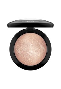 Enlumineur MAC dans un étui rond noir. Le produit a une teinte rose clair chatoyante avec une texture lisse et une brillance subtile.