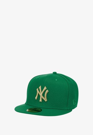 Gorra de béisbol verde con visera plana, que presenta un gran logo de NY bordado en oro en la parte delantera. Fabricada con tela de textura suave.