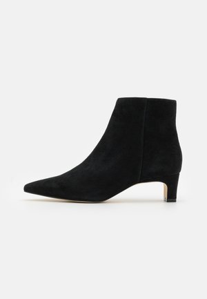 Stivaletto nero in suede con punta appuntita e tacco basso. Design semplice, texture liscia e senza hardware o dettagli visibili.