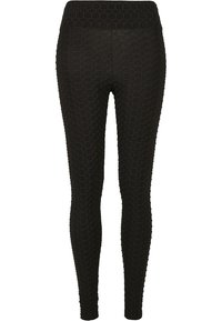 Leggings noirs avec un motif en nid d'abeille texturé, dotés d'une large taille. Fabriqués en tissu extensible, conçus pour un ajustement près du corps.