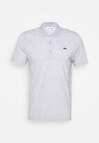 Ljusgrå kortärmad Lacoste polo med tre knappar och en liten grön krokodil-logotyp på vänster bröst.