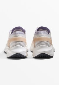 Scarpe atletiche leggere con una tomaia in rete bianca traspirante, accenti in pesca e viola a contrasto, e una suola in gomma nera texturizzata.