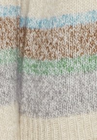 Close-up van gebreide stof met horizontale strepen in blauw, bruin, groen, grijs en crèmekleuren.