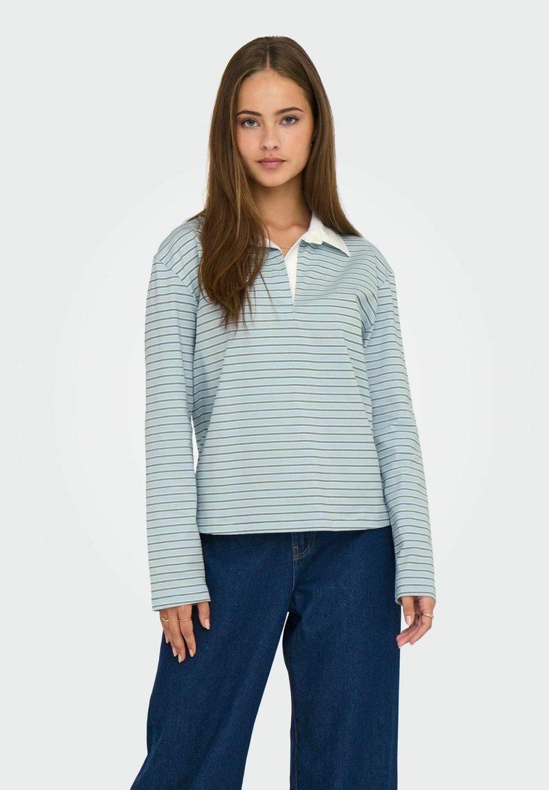 Camiseta de rayas de manga larga en azul claro con un cuello blanco, que presenta un corte relajado y una textura suave, combinada con pantalones vaqueros anchos.