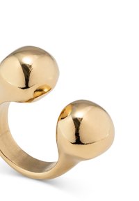 Anillo abierto de tono dorado que presenta dos extremos redondeados. Superficie suave y brillante con una ligera curva, que muestra un diseño contemporáneo.