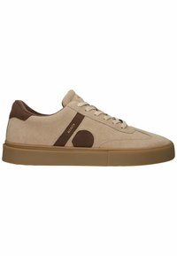 Zapatillas de ante beige con acentos marrones, que presentan un logo redondo, diseño con cordones y suela de goma. Textura suave con detalles en contraste.