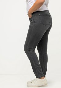 Šedé skinny džíny z denimu s dvěma předními kapsami a zadními kapsami. Obsahují klasický pětikapsový design a jemné švy.