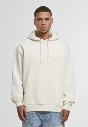 Hellbeige Kapuzenpullover mit Kordelzugkapuze, Fronttasche, gerippten Bündchen und einem minimalen Logo auf der Brust. Weicher, Baumwollmischstoff.