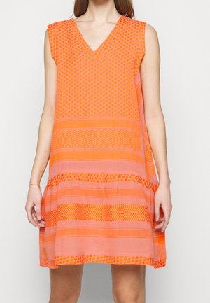 Oranje mouwloze jurk met een V-hals, voorzien van verschillende patronen in donkere en lichtere tinten, en een losse pasvorm die tot halverwege de dij loopt.