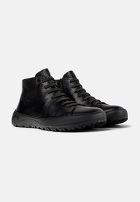 Black leather high-top sneakers with textured finish, round toe, lace-up design, and rubber outsole featuring a rugged tread pattern.