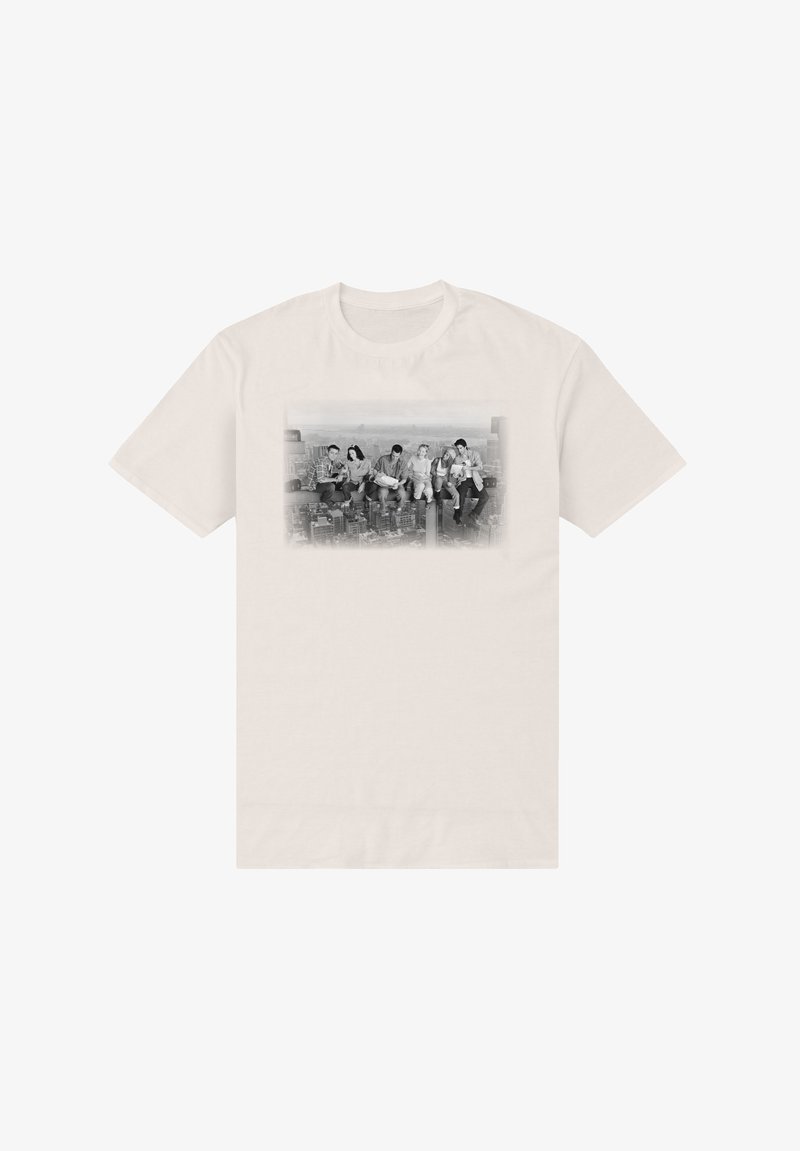 Six people sitting on a steel beam high above a cityscape, depicted in black and white on a light beige T-shirt.