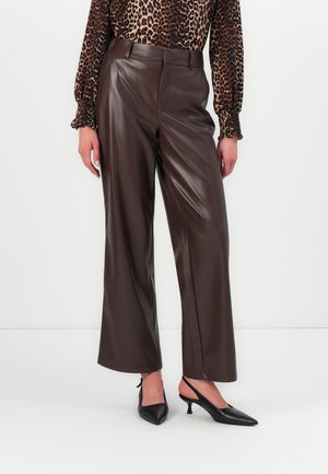 Brune faux skinnbukser med vid benvidde, glatt tekstur og sidelommer, sammen med en bluse med leopardprinte og svarte slingback-heler.