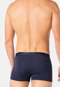 Boxer-briefs bleu marine foncé en tissu doux, dotés d'une ceinture lisse avec un branding discret. Design ajusté avec une allure minimaliste.