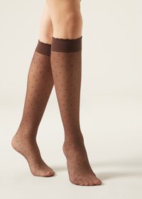 Medias hasta la rodilla de lunares marrones con una textura transparente y un ribete volado en la parte superior, que presentan un patrón de pequeños lunares en toda su superficie.