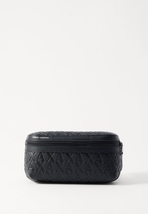 Astuccio nero imbottito con motivo a diamante. Presenta una cerniera superiore e una finitura testurizzata. Forma cilindrica compatta. Etichetta del marchio visibile.