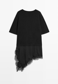 Haut noir à manches courtes avec un ourlet en dentelle asymétrique s'étendant en dessous du tissu principal.