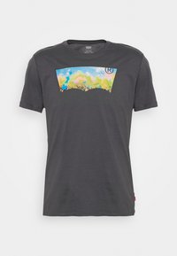 Camiseta de Levi's de color gris oscuro con un gráfico colorido de una multitud y un cielo en forma del logo batwing de la marca en el pecho.