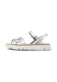 Silver metallic sandal with a chunky white sole, cork footbed, and adjustable straps. Features a small decorative buckle on the upper.