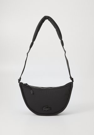 Black quilted shoulder bag with a curved shape, featuring a zip closure, adjustable strap, and embossed logo detail on the front.