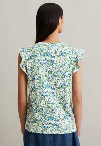 Bloes met bloemenpatroon en korte ruffle-mouwen in groen, blauw en wit. Gemaakt van lichtgewicht stof, heeft een ronde halslijn en een iets losse pasvorm.