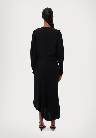 Black dress with long puff sleeves, asymmetrical hem, and smooth texture, featuring a fitted waistline and side draping detail.