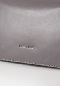 Borsa in pelle grigia con una texture liscia, caratterizzata da un marchio in rilievo e cuciture in contrasto lungo i bordi.