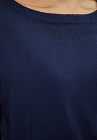 Pulover din tricot de culoare albastru marin, cu o textură netedă, decolteu larg și tiv cu nervuri, prezentând un design simplu și clasic.