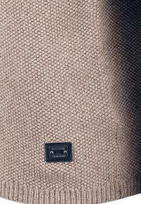 Maglione beige lavorato a maglia con tessuto texturizzato, orlo a coste e un'etichetta nera con "KEY LARGO TRADE MARK" nella parte inferiore.