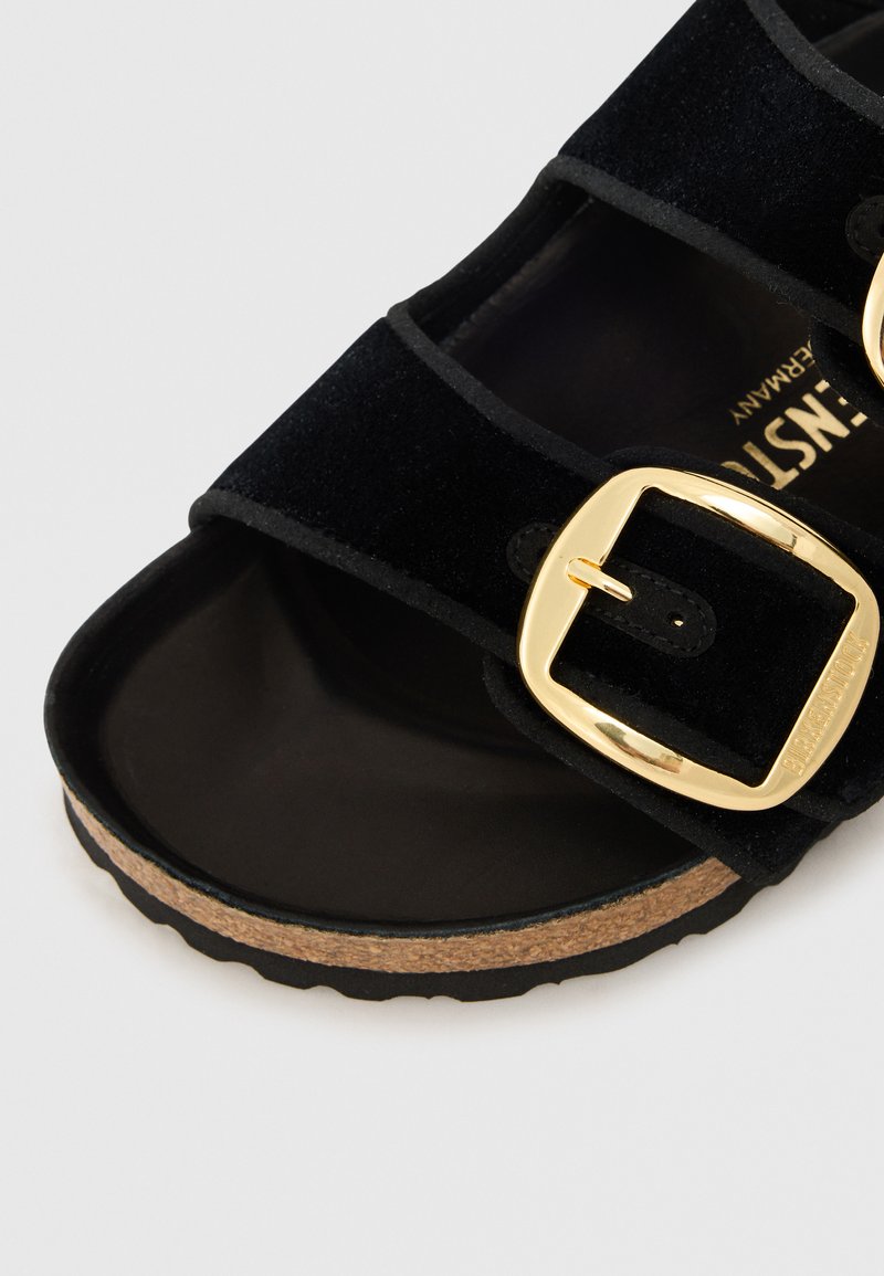 Sandal in suede nero con due cinturini regolabili e fibbie dorate, footbed in sughero e suola in gomma texturizzata.